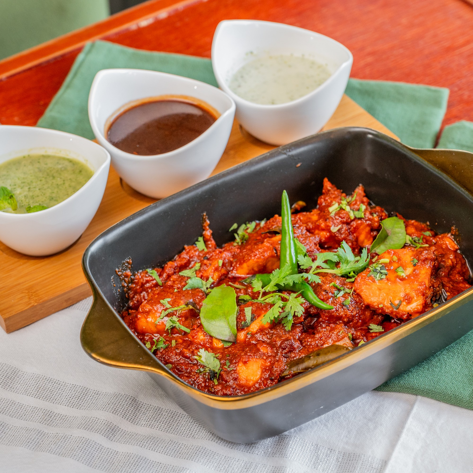 Suma's Kitchen halal chicken curry with green chilies, cilantro, and three dipping sauces.